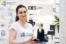 Працівниця ЦНАПу стоїть у білій футболці та посміхається.