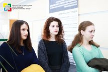 Три жінки перебувають у приміщенні та дивляться убік.