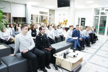 Багато людей сидить у приміщенні.