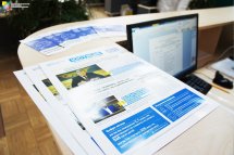 Роздаткові матеріали лежать на реєстраційній стійці.