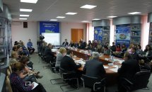 Люди сидять у приміщенні за круглим столом.