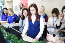 Працівниця демонструє на комп'ютері щось для учасників делегації.
