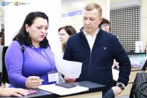 Чоловік та жінка спілкуються у приміщенні ЦНАПу.