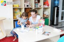 Дівчинка та жінка щось роблять за столом.