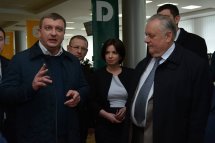 Троє чоловіків та жінка у діловому одязі перебувають в приміщенні.