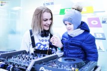Ді-джей та дитина стоять біля діджейського обладнання.