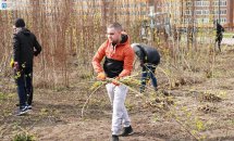 Чоловік у верхньому одязі несе гілки.
