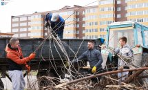 Чоловіки складають гілки на вантажівку.
