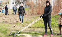 Жінка тримає приладдя для прибирання.