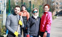 Група людей, які прибирають територію, позують.
