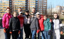 Група людей позує разом, тримаючи зібрані мішки зі сміттям.