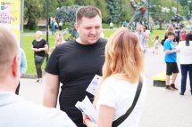 Жінка тримає роздаткові матеріали та спілкується з чоловіком.