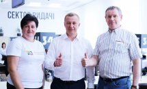 Двоє чоловіків та жінка позують для фото перебуваючи у приміщенні.