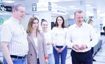 Двоє чоловіків та три жінки про щось спілкуються перебуваючи у приміщенні.