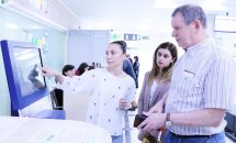 Жінка щось показує на терміналі для чоловіка та жінки.