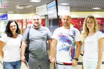 Дві жінки та двоє чоловіків позують у приміщенні.