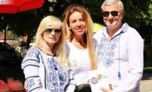 Дві жінки та чоловік фотографуються надворі.