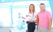 Чоловік та жінка стоять біля бутля з водою та посміхаються.