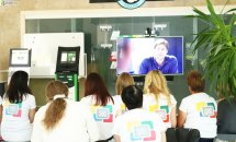 Група людей сидить у приміщенні та дивляться на телевізор.