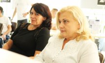 Дві жінки сидять у приміщенні.