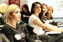 Жінки сидять у приміщенні.