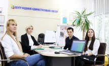 Три жінки та чоловік сидять в кабінеті.