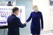 Чоловік тисне руку для жінки у захисній масці.