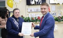 Чоловік та жінка позують з грамотою у руках.