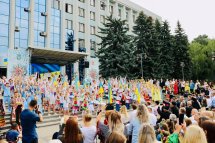 Велика сцена на відкритому майданчику, перед нею – глядачі у вишиванках.