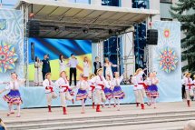 Танцювальний колектив у традиційних українських костюмах виступає на сцені.