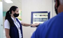 Жінка в захисній масці допомагає людині біля терміналу.