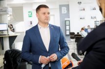 Чоловік у синьому піджаку говорить під час офіційного заходу.