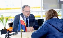 Чоловік у костюмі веде розмову на офіційній події.