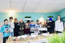 Група дітей та дорослих позують разом у приміщенні.