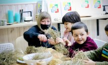 Жінка допомагає дітям майструвати вироби.