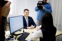 Чоловік спілкується з працівницею за комп’ютером у сучасному офісі.