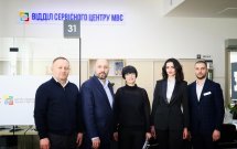 Група співробітників у діловому одязі стоїть разом для загального фото.