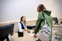 Відвідувачка з рюкзаком розмовляє з працівницею ЦНАПу.