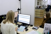 Жінка працює за комп’ютером у офісному приміщенні.