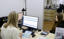 Жінка працює за комп’ютером у офісному приміщенні.