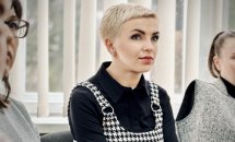 Жінка з короткою зачіскою уважно слухає.