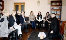 Група людей сидить у класі, на підлозі манекен.