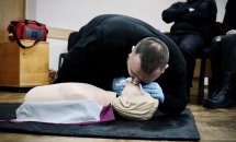 Чоловік проводить штучне дихання на медичному манекені.