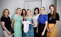 Група людей стоїть разом, дехто усміхається.