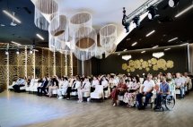 Велика зала з учасниками заходу, сидячими у круговій розстановці.