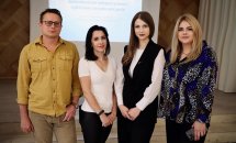 Троє жінок та чоловік позують перед камерою у приміщенні.