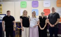 Група людей позують з сертифікатом у руках.