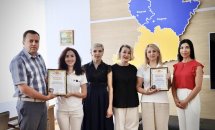 Група людей позують у приміщенні.