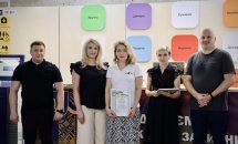 Двоє чоловіків та три жінки позують з сертифікатом у руках.