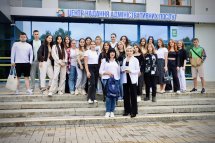 Група людей стоять на сходах перед будівлею.
